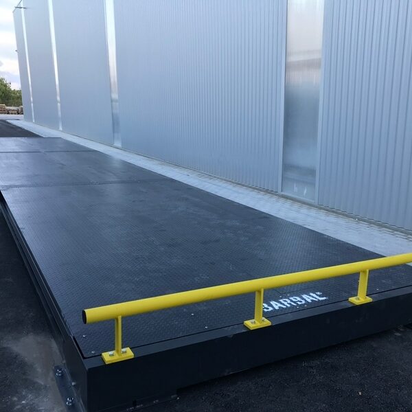 Pont bascule industriel Ademi Pesage avec rampe de sécurité jaune, installation extérieure.