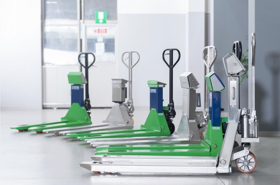 Transpalettes peseurs Ademi Pesage alignés dans un entrepôt moderne.