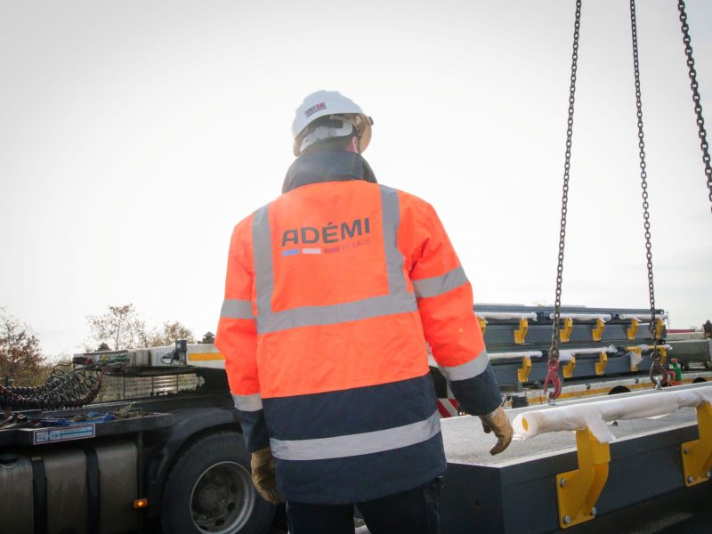 photo service Ademi pesage Technicien Ademi Pesage supervisant un chargement industriel sécurisé sur chantier.
